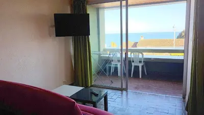 a living room with a view of a table and a balcony at CYSTES in Kamiesch
