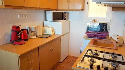 a small kitchen with a stove and a microwave at CYSTES in Kamiesch