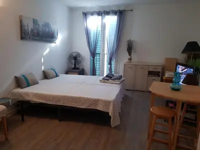 a bedroom with a bed in a room with a table at AJACCIO CENTRE VIEILLE VILLE IMPÉRIALE TT CONFORT TTES COMMODITÉS 3 a 4 PERs CATHÉDRALE A 300M MER PORT MARCHE LOCAL PLAGES in Ajaccio
