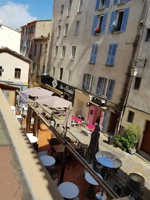 an outdoor patio with tables and umbrellas and buildings at AJACCIO CENTRE VIEILLE VILLE IMPÉRIALE TT CONFORT TTES COMMODITÉS 3 a 4 PERs CATHÉDRALE A 300M MER PORT MARCHE LOCAL PLAGES in Ajaccio