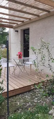 a wooden deck with a table and chairs on it at Casa Prunelli 2 in Omessa