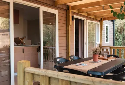 a patio with a table and chairs on a porch at CAMPING GALLINA VARJA in Sotta