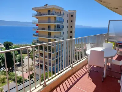 a balcony with a table and a view of the ocean at AJACCIO SANGUINAIRES APPT 3 P POUR 4 A 5 PERSONNES TTES COMMODITÉS TT CONFORT ! A 300M DES PLAGES ET A 5 MN DU CENTRE VILLE in Ajaccio