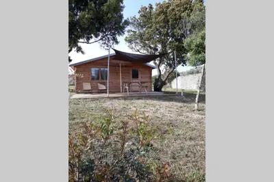 a log cabin with a porch and a yard at Chalet Climatisé SANTA MARIA à Bonifacio in Bonifacio