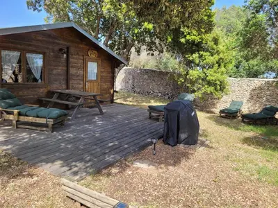 a wooden deck with chairs and a cabin at Chalet Climatisé SANTA MARIA à Bonifacio in Bonifacio