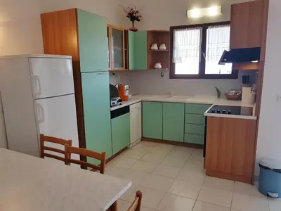 a kitchen with green cabinets and a white refrigerator at ORO 61 in Conca