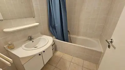 a bathroom with a sink and a toilet and a tub at PALMERAIE 218 in Sari Solenzara