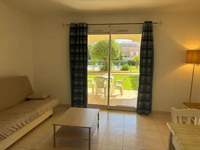 a living room with a couch and a table at PALMERAIE 218 in Sari Solenzara