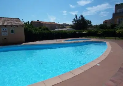 a large blue swimming pool next to a house at PALMERAIE 218 in Sari Solenzara