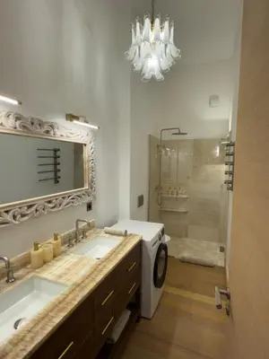 a bathroom with a sink and a washing machine at Entre Ciel et Mer hotel in Bonifacio