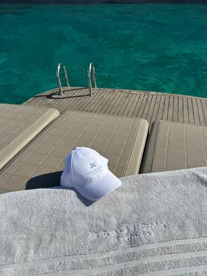 a white hat sitting on a dock next to the water at Entre Ciel et Mer hotel in Bonifacio