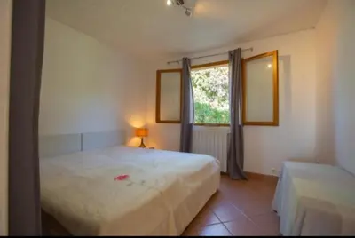 a bedroom with a large bed and a window at Logement calme et agréable à proximité d'Ajaccio in Canale