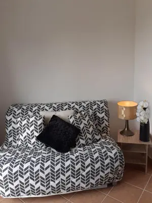 a black and white couch with a black pillow on it at Logement calme et agréable à proximité d'Ajaccio in Canale
