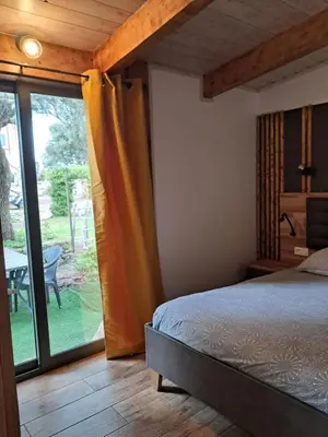 a bedroom with a bed and a sliding glass door at Mini Villa Giuseppina in Bonifacio