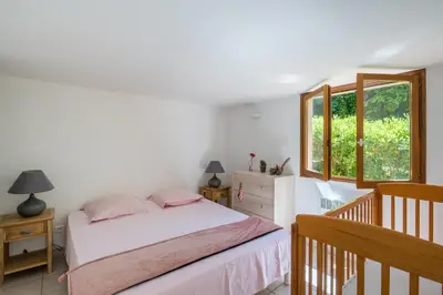 a bedroom with a bed and a window at La Pinède - Maison proche plages in Pietrosella