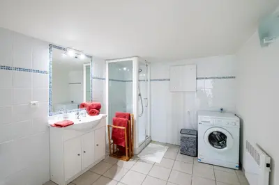 a bathroom with a washing machine and a washer at La Pinède - Maison proche plages in Pietrosella