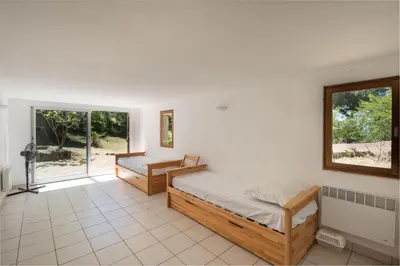 a bedroom with two beds and a window at La Pinède - Maison proche plages in Pietrosella