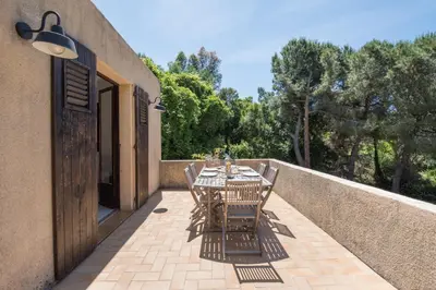 a table and chairs sitting on a patio at La Pinède - Maison proche plages in Pietrosella