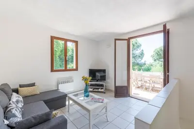 a living room with a couch and a table at La Pinède - Maison proche plages in Pietrosella