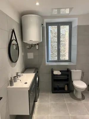 a bathroom with a sink and a toilet and a window at Au cœur de sartene in Sartène