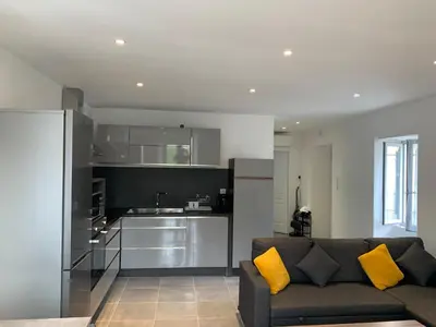 a living room with a couch and a kitchen at Au cœur de sartene in Sartène