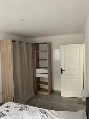 a bedroom with a bed and a closet and a door at Au cœur de sartene in Sartène