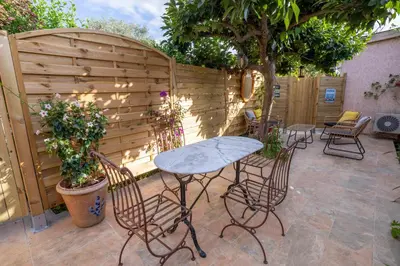 a patio with a table and chairs and a fence at Casa Cardiccia in Folelli