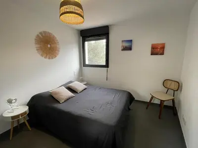 a bedroom with a bed and a window and a chair at Spacieux T3 Proche Port de Porto Vecchio in Porto-Vecchio