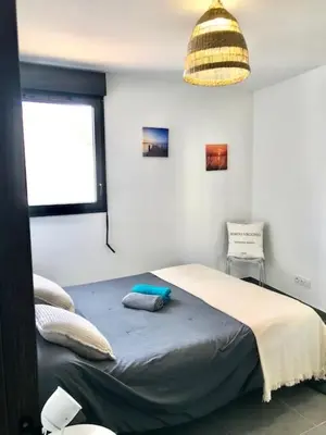 a bedroom with a bed and a pendant light at Spacieux T3 Proche Port de Porto Vecchio in Porto-Vecchio