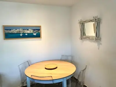 a wooden table in a room with chairs and a mirror at Spacieux T3 Proche Port de Porto Vecchio in Porto-Vecchio