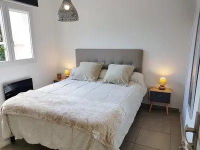 a bedroom with a large white bed with two lamps at SANTA LUCIA in Sainte-Lucie de Porto-Vecchio