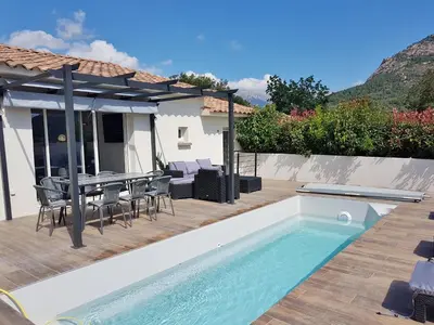 a villa with a swimming pool and a table and chairs at SANTA LUCIA in Sainte-Lucie de Porto-Vecchio