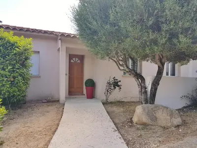 a house with a tree and a door at SANTA LUCIA in Sainte-Lucie de Porto-Vecchio