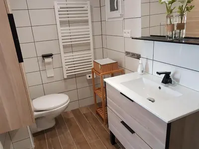 a bathroom with a white sink and a toilet at SANTA LUCIA in Sainte-Lucie de Porto-Vecchio
