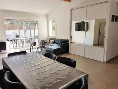 a living room with a table and a couch at SANTA LUCIA in Sainte-Lucie de Porto-Vecchio