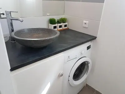 a bathroom with a sink and a washing machine at SANTA LUCIA in Sainte-Lucie de Porto-Vecchio