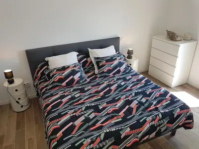a bedroom with a bed with a colorful comforter at SANTA LUCIA in Sainte-Lucie de Porto-Vecchio