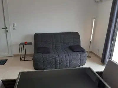 a couch with two pillows sitting in a living room at Studio les pieds dans l'eau vue sur mer in Linguizzetta