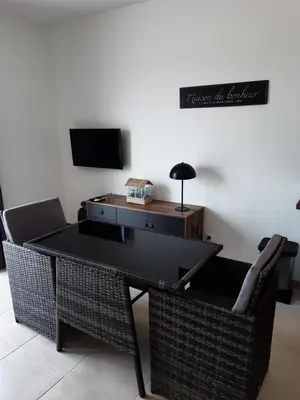 a living room with a table and wicker chairs at Studio les pieds dans l'eau vue sur mer in Linguizzetta
