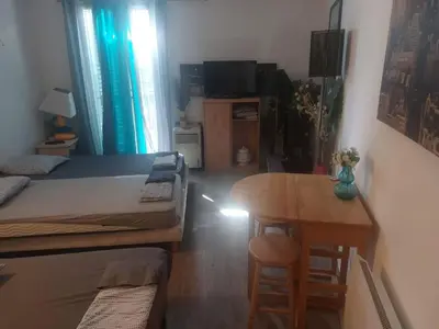 a bedroom with a bed and a table and a desk at VIEILLE VILLE D AJACCIO de 1 a 4 PERs A 300M DU PORT ET A 15 MN DE LAEROPORT PROCHES DE PLUS BELLES PLAGES ET TTES COMMODITES A PROXIMITE in Ajaccio