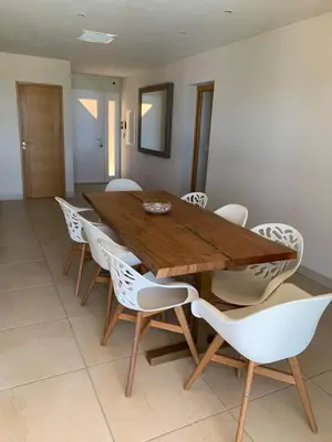 a dining room with a wooden table and white chairs at Maison vue mer Propriano Viggianello in Viggianello