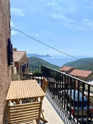 a balcony with a wooden table and a view of the ocean at STUDIO TERRASSE VUE MER Clim Wifi Parking in Partinello