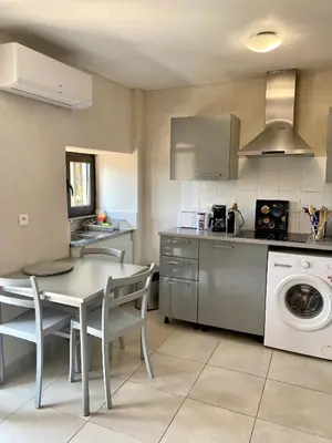 a kitchen with a table and a washing machine at STUDIO TERRASSE VUE MER Clim Wifi Parking in Partinello