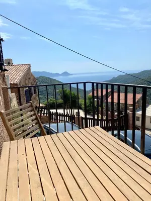 a wooden deck with a bench on a balcony at STUDIO TERRASSE VUE MER Clim Wifi Parking in Partinello
