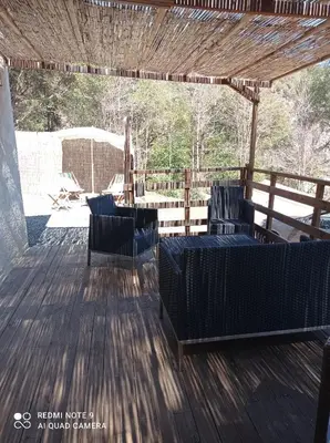 a patio with two chairs and a table on a deck at Maisonnette U Santu Ghjuvandria ou A Santa Ghjulia entre mer et Montagne in Volpajola