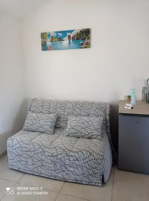 a bed in a bedroom with a picture on the wall at Maisonnette U Santu Ghjuvandria ou A Santa Ghjulia entre mer et Montagne in Volpajola