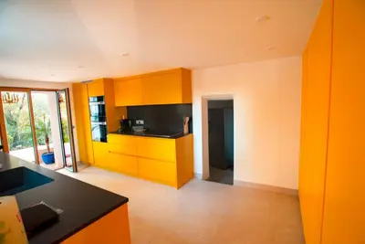 a kitchen with orange cabinets and a black counter top at U Tempu Persu in Grosseto-Prugna