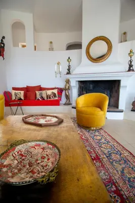 a living room with a yellow chair and a fireplace at U Tempu Persu in Grosseto-Prugna