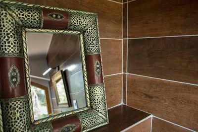 a mirror on a tiled wall in a bathroom at U Tempu Persu in Grosseto-Prugna
