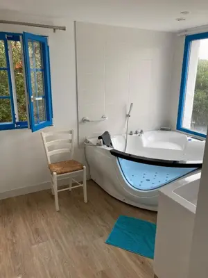 a bathroom with a tub and a chair next to a bath tub at Villa vue sur mer Corse Blanca Casa à PORTICCIO AJACCIO in Grosseto-Prugna